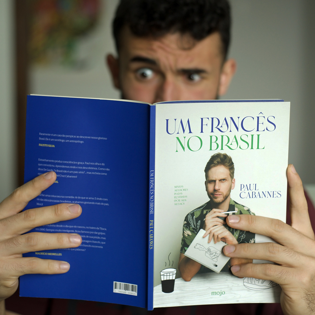 Pessoa a ler Um francês no Brasil, com a capa, a lombada e a contracapa à vista