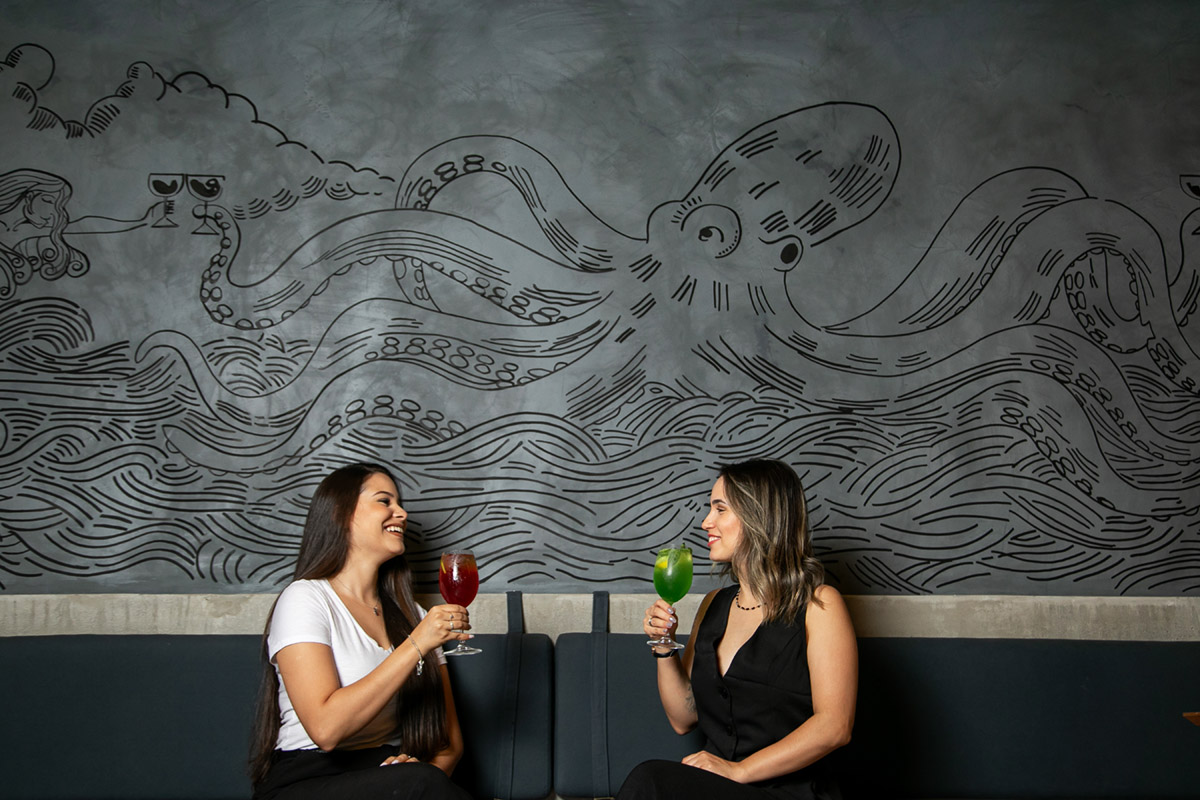 Octopus mural drawn on the wall at Benta, with two diners at the table