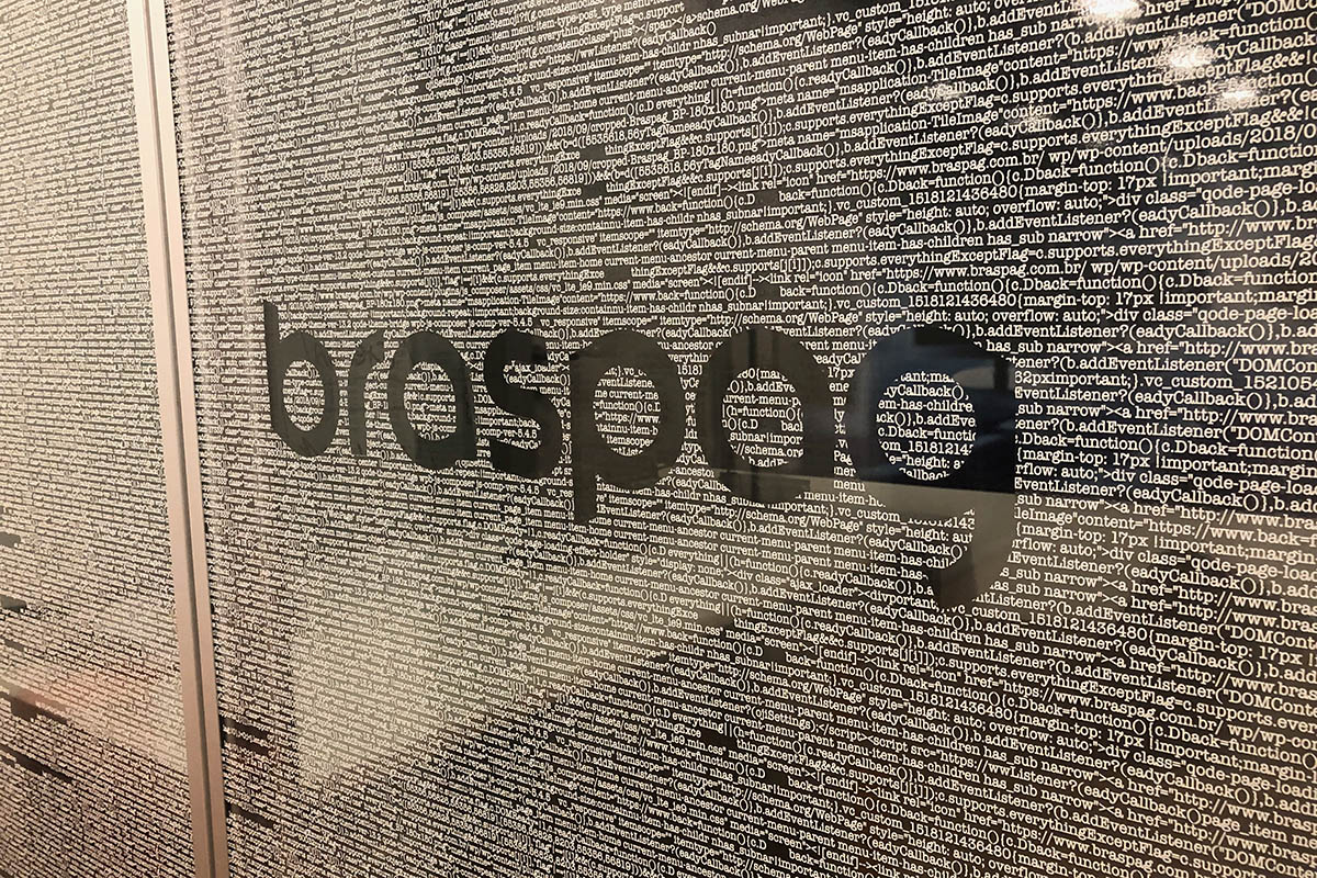 Glass partition with the Braspag logo and a text pattern