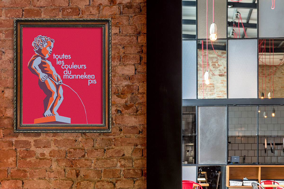 Framed Manneken Pis illustration on the brick wall at Chez Vous