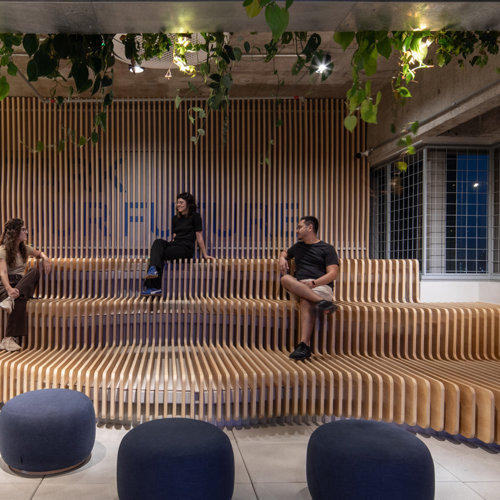 People sitting on the slatted seating, with the tagline Stark your future in the background