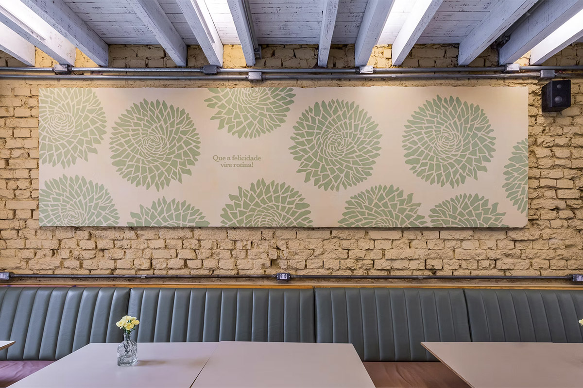 Panel with a green floral pattern on a brick wall, in a Dona Vitamina shop